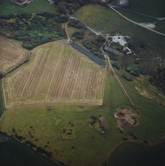 Oblique aerial view centred on the remains of the recumbent stone circle, dovecot and country house with the building adjacent, taken from the N.