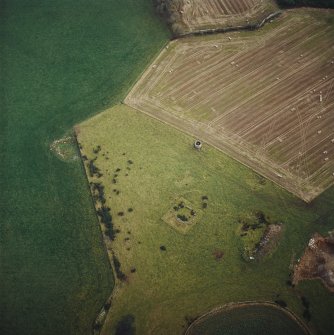 Oblique aerial view centred on the remains of the recumbent stone circle and dovecot, taken from the NW.