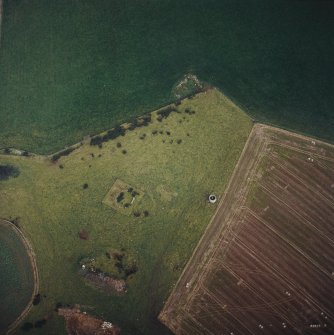 Oblique aerial view centred on the remains of the recumbent stone circle and dovecot, taken from the WSW.