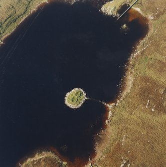 Oblique aerial view of Loch nan Cinneachan centred on the remains of an island dwelling on a crannog, taken from the SE.