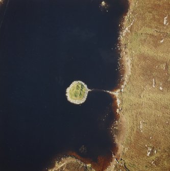Oblique aerial view of Loch nan Cinneachan centred on the remains of an island dwelling on a crannog, taken from the SSE.