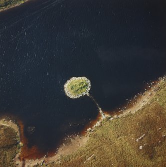 Oblique aerial view of Loch nan Cinneachan centred on the remains of an island dwelling on a crannog, taken from the ESE.