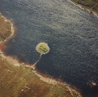 Oblique aerial view of Loch nan Cinneachan centred on the remains of an island dwelling on a crannog, taken from the NE.