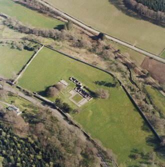Oblique aerial view centred on the remains of the abbey and the house, taken from the NW.