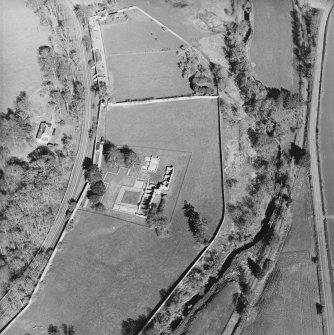 Oblique aerial view centred on the remains of the abbey and the house and walled garden, taken from the WSW.