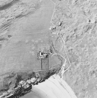 Oblique aerial view of Crossapol centred on a house and the remains of a farmstead and burial ground, taken from the SE.