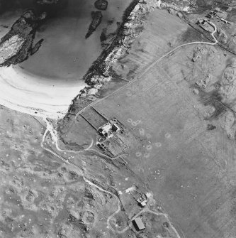 Oblique aerial view of Caoles and Crossapol centred on a farmstead and sheepfold, a house and the remains of two farmsteads and a burial ground, taken from the NNW.