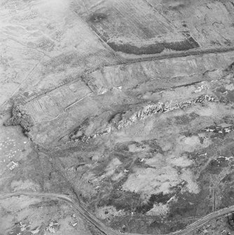 Oblique aerial view of Dun an Achaidh centred on the remains of a dun, taken from the NNW.