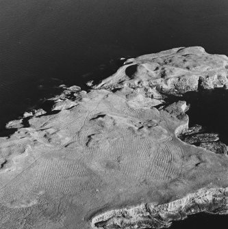 Oblique aerial view of Staffa, taken from the north, centred on building remains.