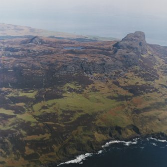 General oblique aerial view centred on the remains of the township, field-system, rig and lazy-beds with An Sgurr fort adjacent, taken from the WSW.