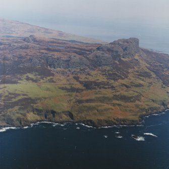General oblique aerial view centred on the remains of the township, field-system, rig and lazy-beds with An Sgurr fort adjacent, taken from the SW.