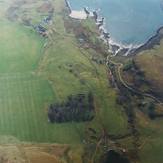 Oblique aerial view centred on the remains of the church with farmhouse, barn and farmsteading adjacent, taken from the N.