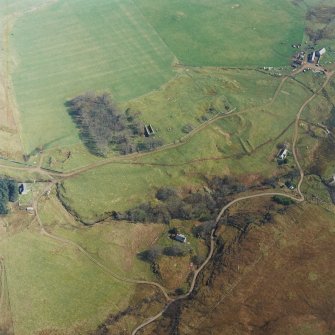 Oblique aerial view centred on the remains of the church with farmhouse, barn and farmsteading adjacent, taken from the WNW.