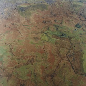 Oblique aerial view centred on the remains of the township and field-system with farmstead adjacent, taken from the W.