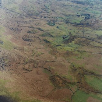 Oblique aerial view centred on the remains of the township and field-system with farmstead adjacent, taken from the NNE.