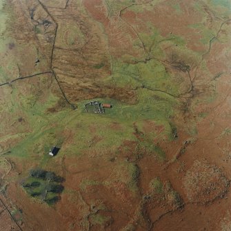 Oblique aerial view centred on the remains of the township and field-system with farmstead adjacent, taken from the E.