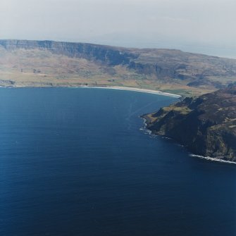 General oblique aerial view centred on the Bay of Laig with the crofting township beyond and the remains of the fort adjacent, taken from the W.