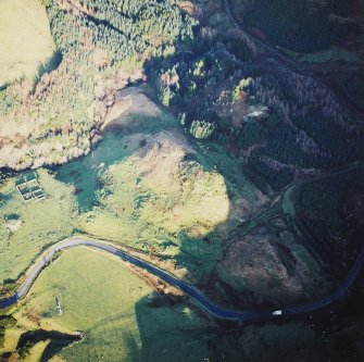 Oblique aerial view centred on the remains of the fort with the remains of the cairn adjacent, taken from the WSW.