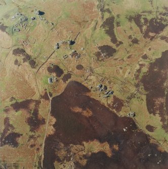 Oblique aerial view centred on the remains of the township, field-system, rig, lazy-beds, dun and shepherd¿s bothy, taken from the E.