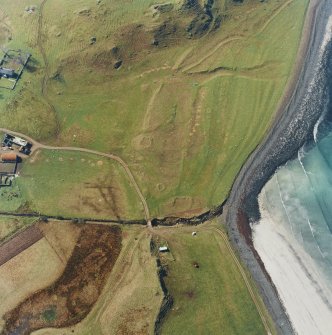 Oblique aerial view centred on the remains of the square cairn cemetery with the remains of enclosures adjacent, taken from the E.