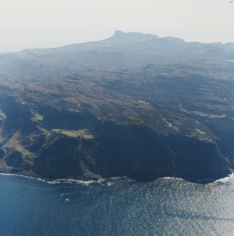 General oblique aerial view of the west side of Eigg with the fort in the foreground and the Sgurr fort beyond, taken from the NNW.