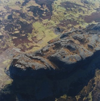 Oblique aerial view centred on the E end of An Sgurr and the remains of the fort, taken from the NNE.