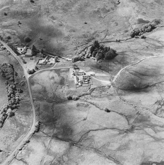 Oblique aerial view centred on the remains of the barracks and a farmsteading, from E.