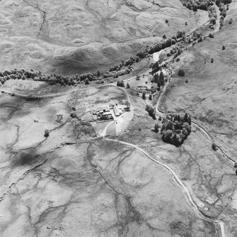 Oblique aerial view centred on the remains of the barracks, and a farmsteading, from N.