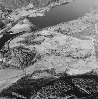 Oblique aerial view of Anie centred on a farmstead, the remains of a field-system, rig, military road and limekiln, taken from the SE.