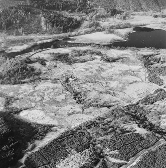 Oblique aerial view of Anie centred on a farmstead, the remains of a field-system, rig and a military road, taken from the ESE.