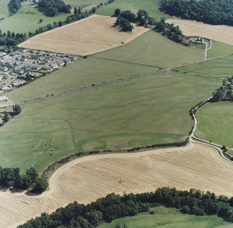 Dalginross, oblique aerial view, taken from the WNW, centred on the cropmarks of the Roman Fort and the Temporary Camp.