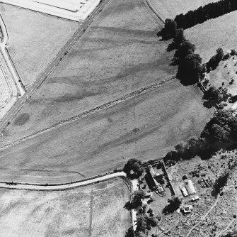 Tullichettle, oblique aerial view, taken from the NNW, centred on the cropmarks of an old road, and a pit-defined cursus monument.