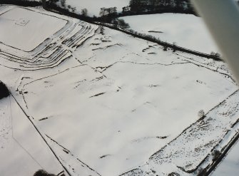 Oblique aerial view centred on temporary camps and fort under cover of snow.