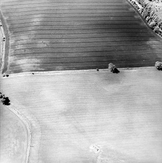 Oblique aerial view centred on the remains of the water tank with the  cropmarks of the Roman watch tower and quarry pits adjacent , taken from the E.