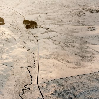 Oblique aerial photograph of Girron Burn centred on the remains of field-banks, rig and clearance cairns, taken from the NE.