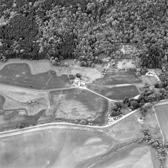 Oblique aerial view of Castle Menzies centred on a tower house, well, walled garden and military road, and the crop marks of pits, a garden and linear cropmarks, taken from the SSE.