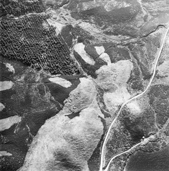 Oblique aerial view centred on the remains of possible shieling-huts, trackway and possible hut-circle, taken from the ENE.