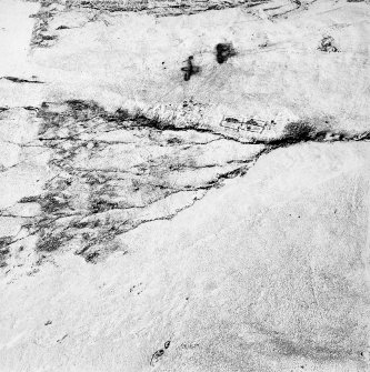 Oblique aerial view centred on the remains of enclosures and rig, taken from the SW.