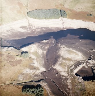 Oblique aerial view centred on the remains of farmsteads, enclosures and sheepfold with quarry and sheep shelter adjacent, taken during low water from the S.