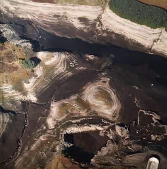 Oblique aerial view centred on the remains of farmsteads, enclosures and sheepfold with quarry and sheep shelter adjacent, taken during low water from the SSE.