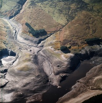 Oblique aerial view centred on the remains of farmsteads, enclosures and sheepfold with quarry and sheep shelter adjacent, taken during low water from the NNE.