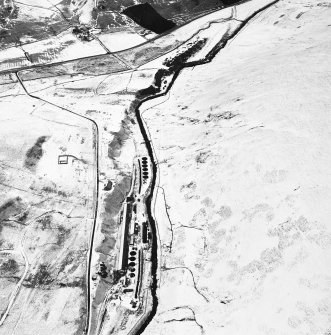 Oblique aerial view centred on the remains of buildings, enclosure, hut and lazy-beds with huts, enclosures, field-system, plantation bank, sheepfold, quarry, trackways, farmstead and field banks adjacent, taken from the SW.