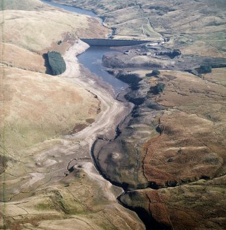 General oblique aerial view centred on the reservoir with quarry, farmsteads, enclosures, sheepfold and possible motte adjacent, taken during low water from the W.