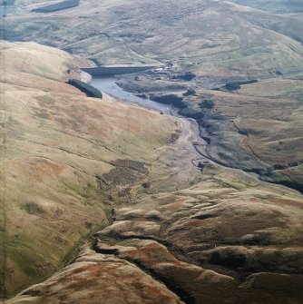 General oblique aerial view centred on the reservoir with sheepfold and possible motte adjacent, taken during low water from the WNW.
