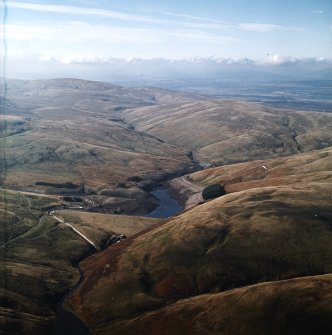 General oblique aerial view centred on the reservoir and dam, taken during low water from the ENE.