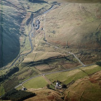 Oblique aerial view centred on the remains of the farmstead, sheepfold, rig and field-system with trackways and plantation bank adjacent, taken from the NE.