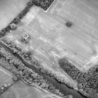 Oblique aerial view centred on the cropmarks of the pit-alignment, garden and fort with the remains of the tower house adjacent, taken from the ESE.