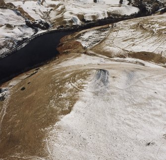 Oblique aerial view centred on the remains of the fort with farmstead, head-dyke, field-banks and rig adjacent, taken from the ESE.