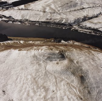 Oblique aerial view centred on the remains of the fort with field system adjacent, taken from the NE.