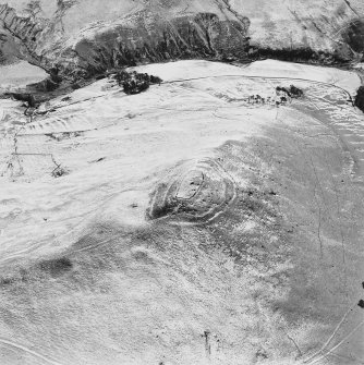 Oblique aerial view centred on the remains of the fort with field-system and rig adjacent, taken from the NW.